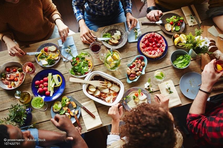 Freunde essen an Tisch ein leckeres Abendessen